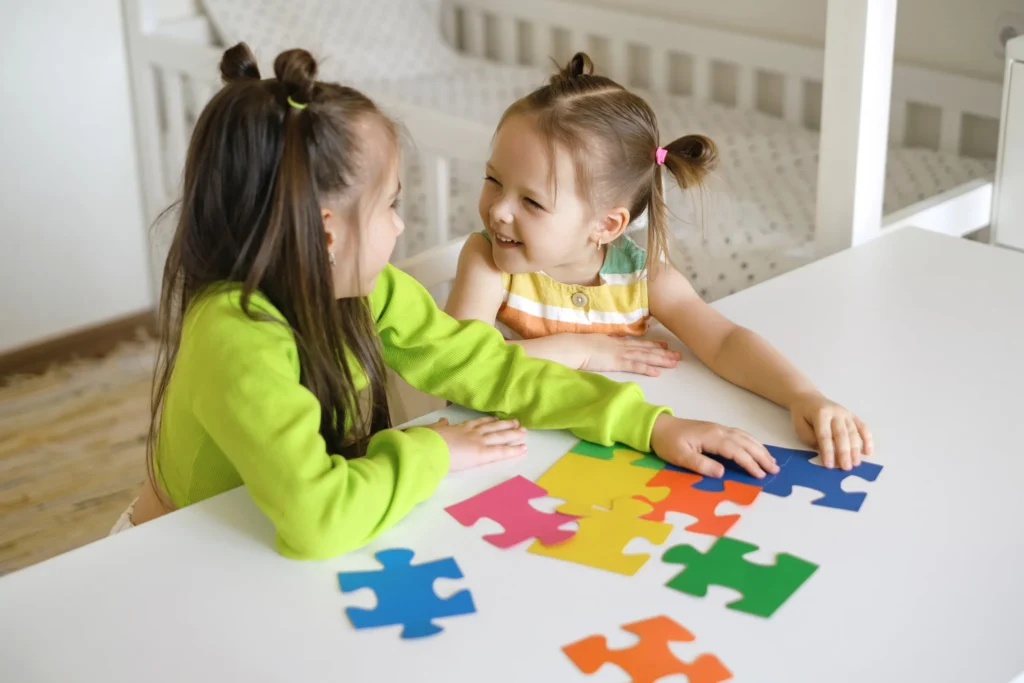 Two young girls smiling and playing at Neuro Spark.